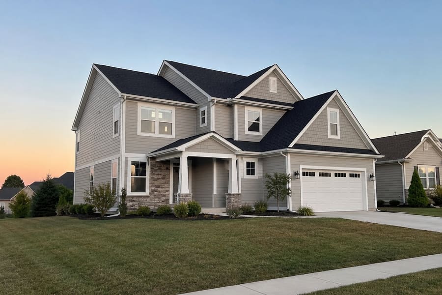 Aerial view of a two-story home with a charcoal architectural shingle roof across multiple gables